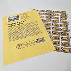 May include: A sheet of Vietnam Veterans Regular Issue stamps and a First Day of Issue envelope. The stamps feature a gold and red design. The envelope is yellow with black text and a stamp image.