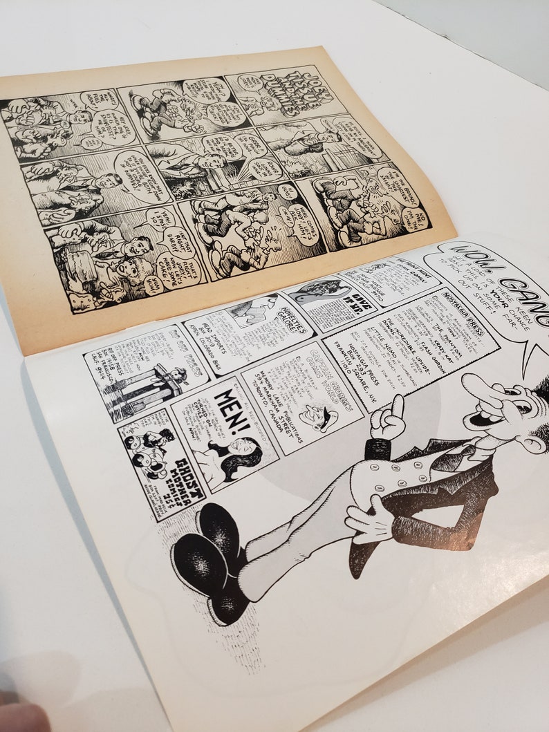 May include: A vintage comic book open to two pages of black and white illustrations. The top page shows a comic strip with speech bubbles. The bottom page has a cartoon man and advertisements. Text includes "Wow Gang" and "Men!"