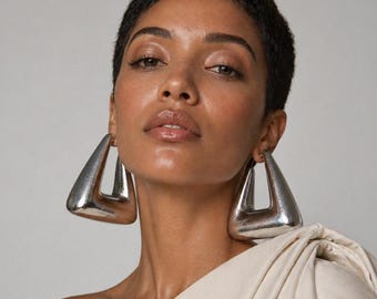 Puede incluir: Pendientes triangulares geométricos plateados. Los pendientes tienen un diseño hueco y abierto. Un accesorio atrevido y moderno.