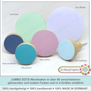Peut inclure: Assortiment de crochets muraux ronds en bois de différentes couleurs, notamment vert menthe, lavande, rose, bleu et sarcelle. Les crochets sont étiquetés avec des numéros et des noms de couleurs, tels que #10 menthe, #24 lilas, #49 mauve, #20 bleu clair, #48 bleu foncé et #25 pétrole. Le texte "JUMBO DOTS Wandhaken in über 80 verschiedenen glänzenden und matten Farben und in 4 Größen erhätlich 100% handgefertigt 100% handbemalt 100% MADE IN GERMANY" est en bas de l'image.