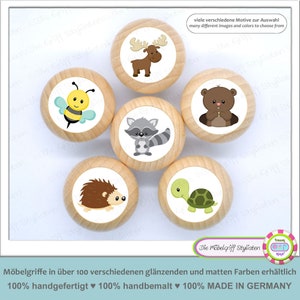 May include: Six wooden knobs with different animal illustrations. The knobs feature a moose, bee, raccoon, hedgehog, turtle, and bear. The knobs are painted in various colors, including brown, black, white, yellow, green, and blue.