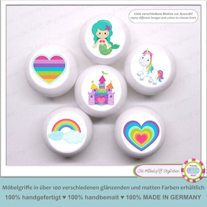 May include: White cabinet knobs with colorful designs, including a rainbow, heart, mermaid, castle, and unicorn. The knobs have a glossy finish and are perfect for adding a touch of whimsy to furniture. The text says "many different images and colors to choose from".