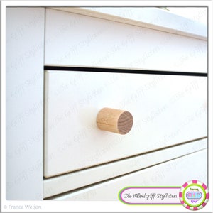 May include: A white drawer with a wooden knob. The drawer is labeled with the text "Die Möbelgriff Stylisten".
