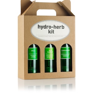 May include: A brown cardboard box with a handle, labelled "hydro-herb kit" and containing three glass bottles of herbs: dill, flat parsley, and coriander.
