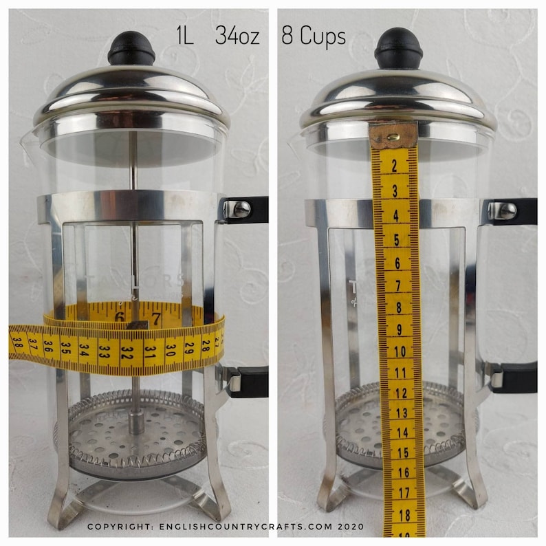 May include: A stainless steel French press coffee maker with a glass carafe and a measuring tape around the carafe. The carafe holds 1 litre, 34 ounces or 8 cups of coffee. The text "1L 34oz 8 Cups" is printed on the top of the image.