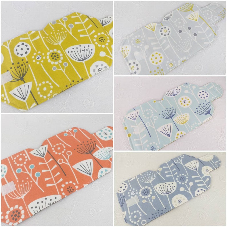 May include: Four different fabric pouches with a floral pattern. The pouches are in shades of yellow, blue, orange, and grey. The floral pattern features stylised flowers with white stems and black dots.