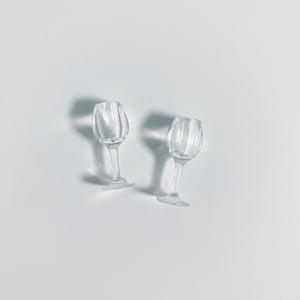 May include: Two clear glass wine glasses with a ribbed design on a white background.