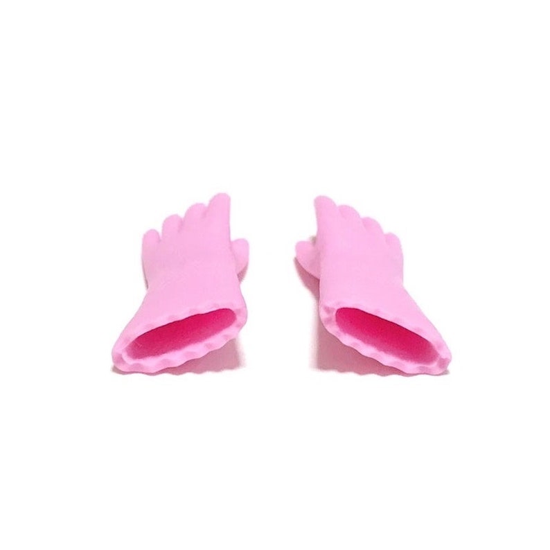 May include: Two pink, miniature hand-shaped objects with a contrasting dark pink interior. The fingers are slightly curved, and the overall design is smooth and rounded. The objects are set against a plain white background.