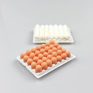 May include: Two white egg cartons, one filled with white eggs and the other filled with brown eggs.