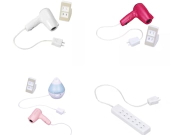 May include: A collection of miniature white and pink hair dryers, a white power strip, and a small humidifier. Each item has a white cord and a plug. The items are set against a white background.