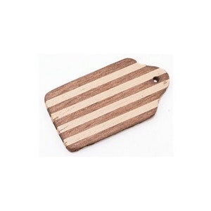 Puede incluir: Una pequeña tabla de cortar de madera con un diseño a rayas. La tabla es marrón con rayas blancas y tiene un agujero en la parte superior.