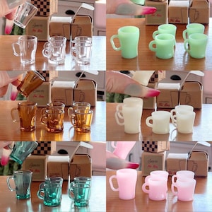 以下が含まれることがあります： 緑、白、ピンク、茶色、青など、さまざまな色のミニチュアティーカップ10個セット。カップは木製の表面に3つずつ並べてあります。各カップのグループには、「Jate Tea For King」と書かれた小さな段ボール箱が付いています。