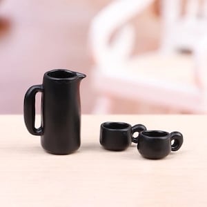 以下が含まれることがあります： 黒いピッチャーと黒いマグカップ2つ。ピッチャーにはハンドルと注ぎ口があります。マグカップにはハンドルが付いています。このセットはプラスチック製で、ドールハウスやミニチュア遊び用に設計されています。
