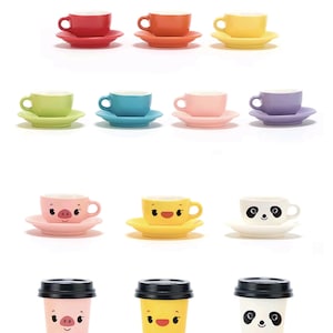 May include: A collection of colorful ceramic teacups and saucers in various colors, including red, orange, yellow, green, blue, pink, and purple. There are also cups with animal faces, including a pig, a chick, and a panda. Below are matching to-go cups.