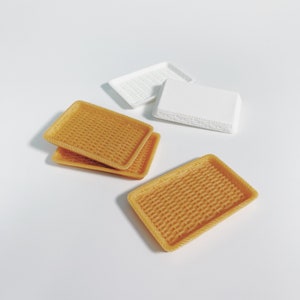 May include: Four small woven trays, two are white and two are a light brown color. The trays are stacked on top of each other.