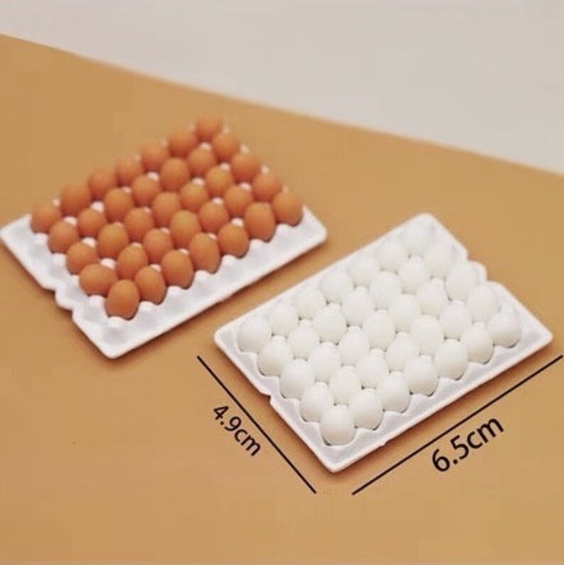 May include: Two white egg cartons, one filled with brown eggs and the other with white eggs. The cartons are 4.9 inches by 6.5 inches.