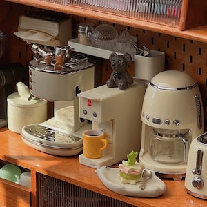 Peut inclure: Ensemble de trois tasses en c&eacute;ramique avec une finition mate et mouchet&eacute;e. Les tasses sont de couleur cr&egrave;me, gris clair et gris fonc&eacute;. Chaque tasse a un design simple et minimaliste, id&eacute;al pour le caf&eacute; ou le th&eacute;.