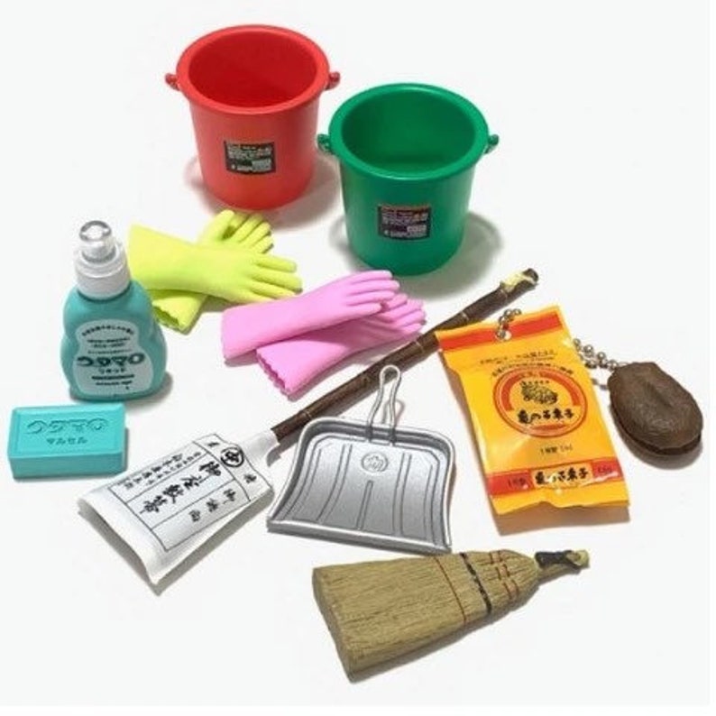 May include: A collection of miniature cleaning supplies, including red and green buckets, yellow and pink gloves, a broom, dustpan, soap, and a bottle of cleaner. The items are arranged on a white surface.