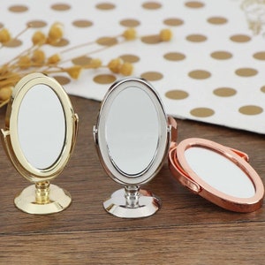 Puede incluir: Tres espejos de mesa ovalados con soportes. Los espejos son de color dorado, plateado y oro rosa.