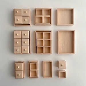 Puede incluir: Conjunto de nueve cajas de madera con diferentes configuraciones de cajones y compartimentos. Las cajas son todas de madera natural y tienen un acabado marrón claro.