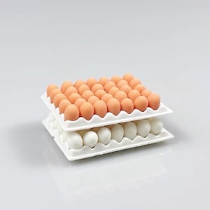 May include: A white egg carton filled with two layers of eggs. The top layer has 30 orange eggs and the bottom layer has 12 white eggs.