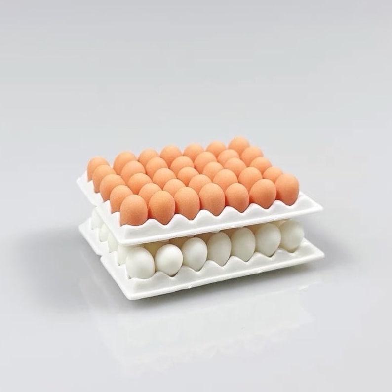 May include: A white egg carton filled with two layers of eggs. The top layer has 30 orange eggs and the bottom layer has 12 white eggs.