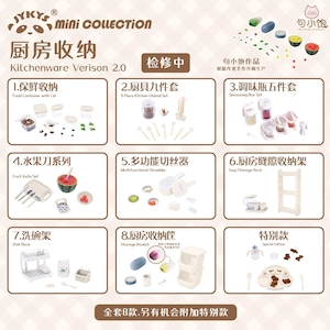 Può includere: Un set di otto articoli da cucina in miniatura, tra cui un set di coltelli per la frutta, uno sminuzzatore multifunzionale, un set di barattoli per condimenti, uno scolapiatti, un cesto portaoggetti, un ripiano portaoggetti per spazi stretti, un set di utensili da cucina e un set di contenitori per alimenti con coperchi. Gli articoli sono tutti bianchi e hanno un design realistico. Il testo "Kitchenware Version 2.0" è stampato nella parte superiore dell'immagine.