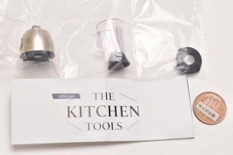 May include: A set of miniature kitchen tools, including a blender, a food processor, and a small coin with Japanese text. The tools are made of plastic and metal and are painted in a realistic style. The set is packaged in a clear plastic bag with a white card that reads "The Kitchen Tools" and "Official".
