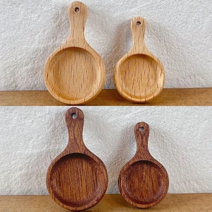 Puede incluir: Dos juegos de cucharas de madera, un juego es de color marrón claro y el otro es de color marrón oscuro. Las cucharas tienen todas la misma forma, con un cuenco redondo y un mango largo.