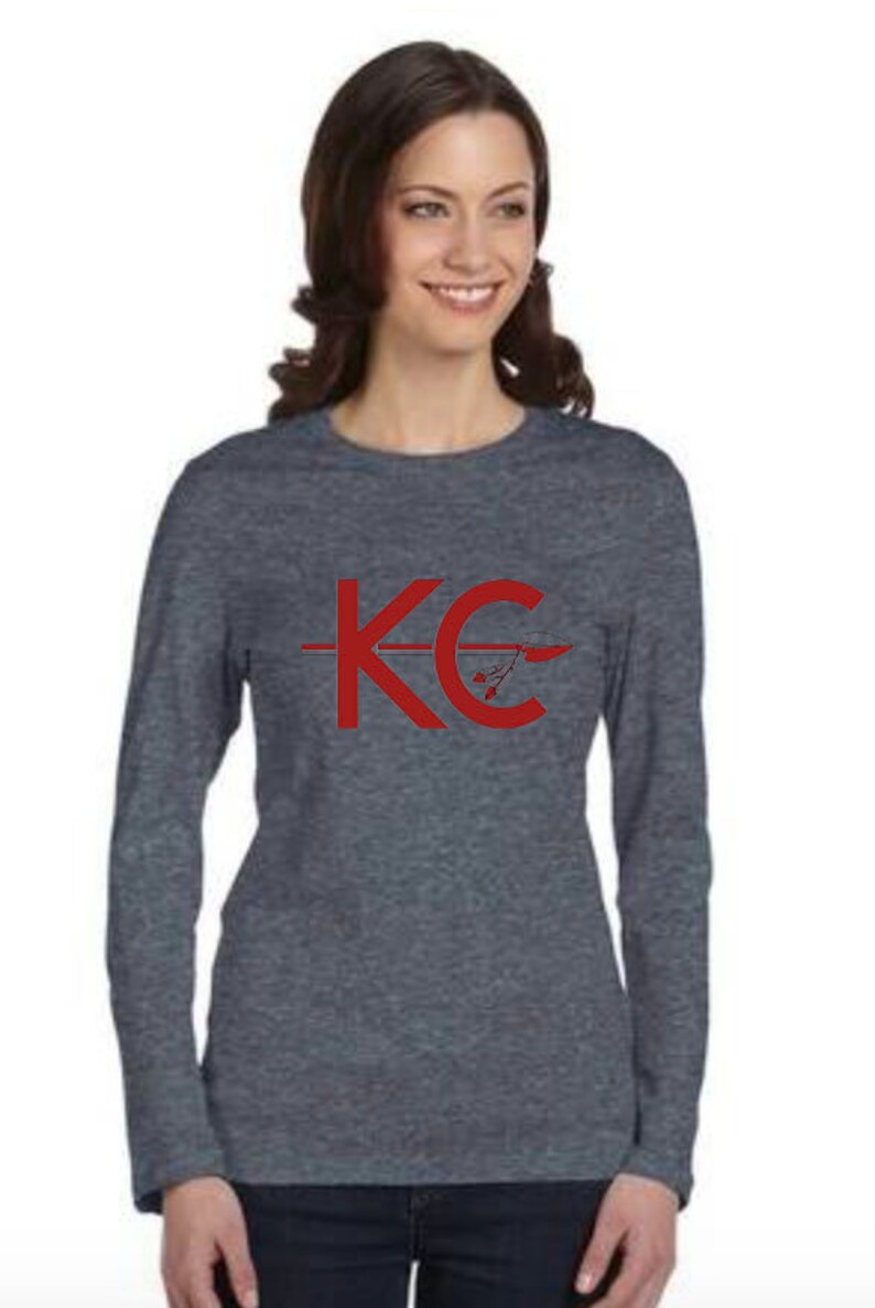 May include: A heather gray long-sleeve shirt with a red graphic of the letters "KC" with an arrow through the "C".
