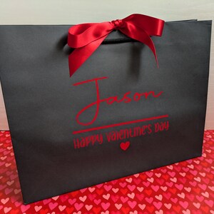 Black Valentine's gift bag with the name "Jason" in large text, with "Happy Valentine's Day" below in smaller text.