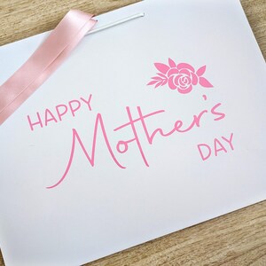 Mothers Day gift bag with pink text and ribbon.