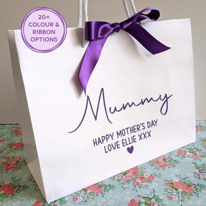 White gift bag for Mother's Day. The bag shown has purple text and a purple ribbon, with Mummy in large text, and a personalised message below.