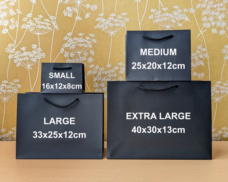 Four black gift bags of different sizes. The bags are labelled with the size and dimensions in centimetres: Small 16x12x8cm, Large 33x25x12cm, Medium 25x20x12cm, Extra Large 40x30x13cm.