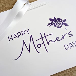 White gift bag with purple "Happy Mother's Day" text and a floral motif.