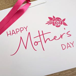 Happy Mother's Day gift bag with pink text and ribbon.
