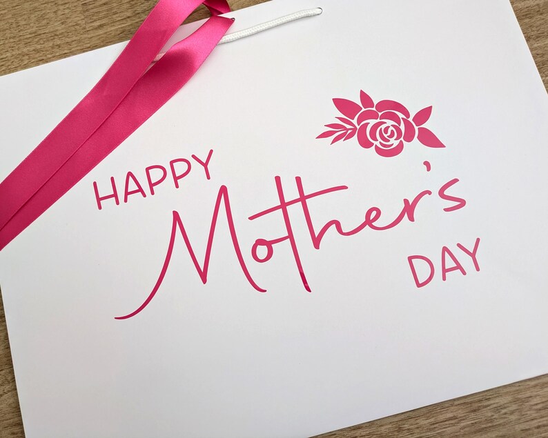 Happy Mother's Day gift bag with pink text and ribbon.