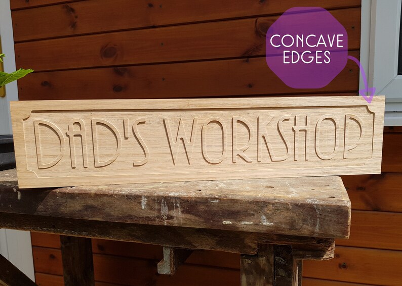 May include: A wooden sign with the text "Dad's Workshop" carved into it. The edges of the sign are concave.