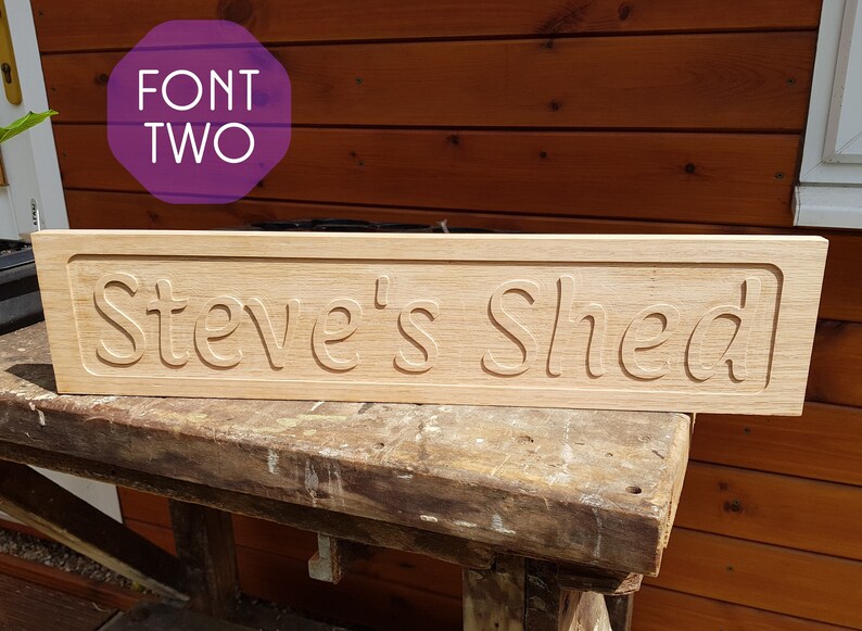 May include: A wooden sign with the text "Steve's Shed" carved into it. The sign is light brown and has a slightly distressed look.