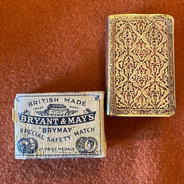 Antique brass and red match box cover with original match box.