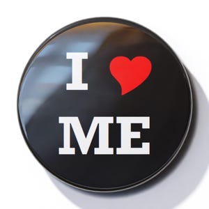 May include: A black button with a white "I love ME" message and a red heart.