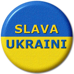 Puede incluir: Un botón redondo con los colores de la bandera ucraniana, azul y amarillo. El botón tiene el texto "SLAVA UKRAINI" en letras amarillas y azules.