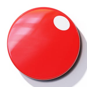 May include: A large, round, red button with a smaller white circle in the upper right corner.
