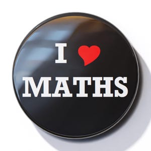 May include: A black button with a white border and the text "I ♥ MATHS" in white letters. The heart is red.