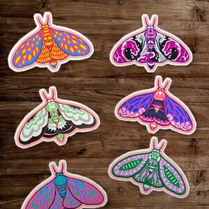 Puede incluir: Seis pegatinas de polilla coloridas con intrincados patrones y detalles. Las polillas son de varios colores, incluyendo rosa, azul, verde, morado y naranja. Las pegatinas son perfectas para agregar un toque de fantasía a cualquier superficie.
