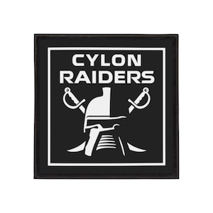 Puede incluir: Parche cuadrado negro con texto y gráficos blancos. El texto dice "CYLON RAIDERS" encima de una ilustración blanca de un casco y espadas cruzadas. El parche tiene un borde negro.