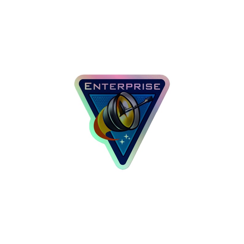 Pode incluir: Um adesivo triangular com borda hologr&aacute;fica, fundo azul escuro e a palavra ENTERPRISE em letras mai&uacute;sculas brancas. O design inclui uma antena parab&oacute;lica met&aacute;lica estilizada com um rastro de chama amarela e pequenas estrelas brancas.