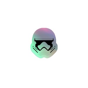 May include: A holographic sticker featuring the stylized black silhouette of a stormtrooper helmet. The helmet design includes a horizontal visor line, a central nose piece, and angled cheek vents, all set against a shifting iridescent background.