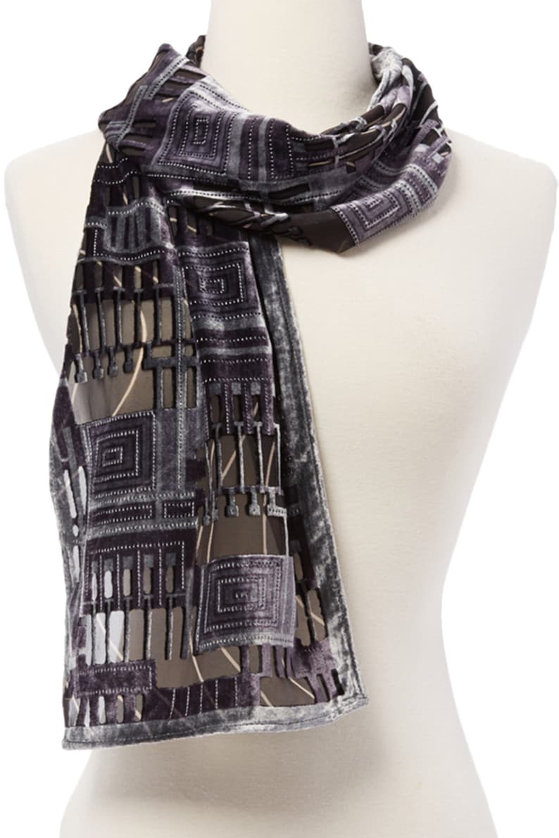 May include: A gray and silver geometric patterned scarf with a velvet texture. The scarf has a cut-out design that reveals a sheer fabric underneath.