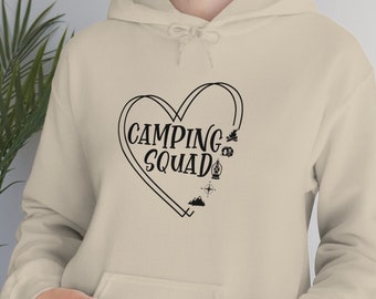 May include: A beige hoodie with a black heart graphic that says "Camping Squad" inside the heart. The heart graphic also includes a campfire, a tent, a lantern, a mountain, and a compass.